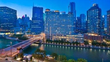 Sheraton Grand Chicago Riverwalk at dusk with city lights