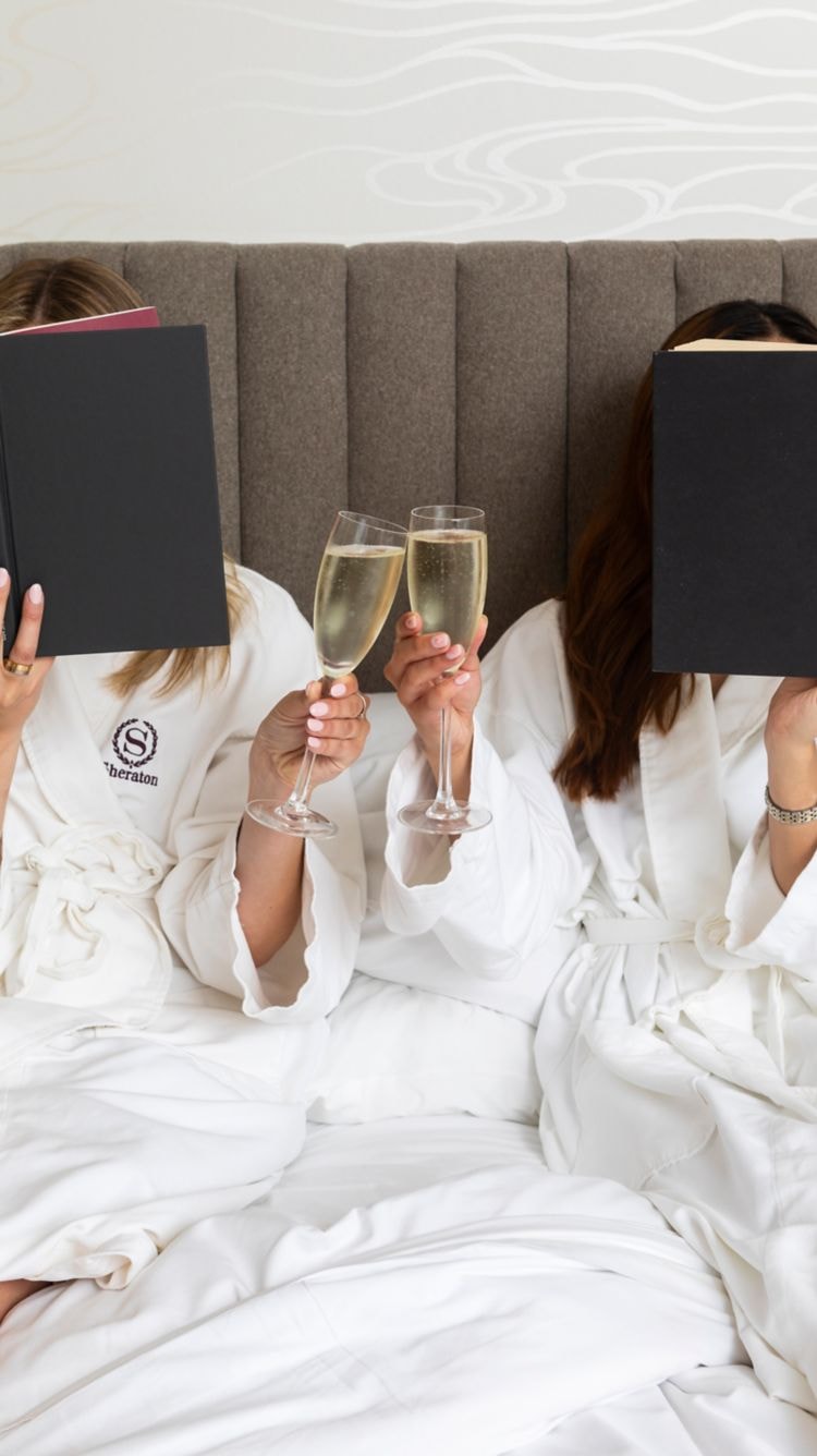 Guests relaxing in Sheraton robes with champagne